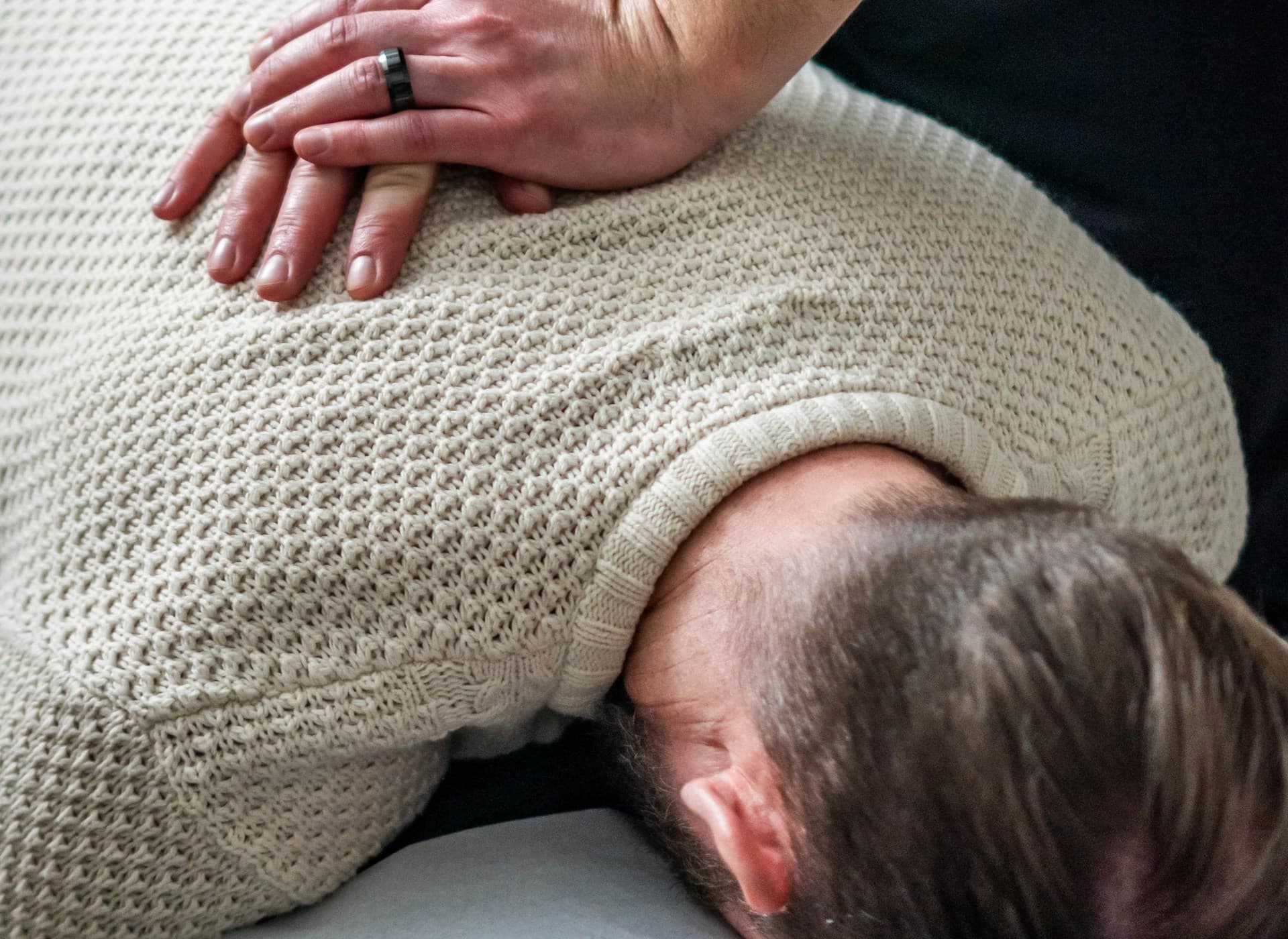 Chiropractor gently performing a spinal adjustment on a patient's upper back and neck