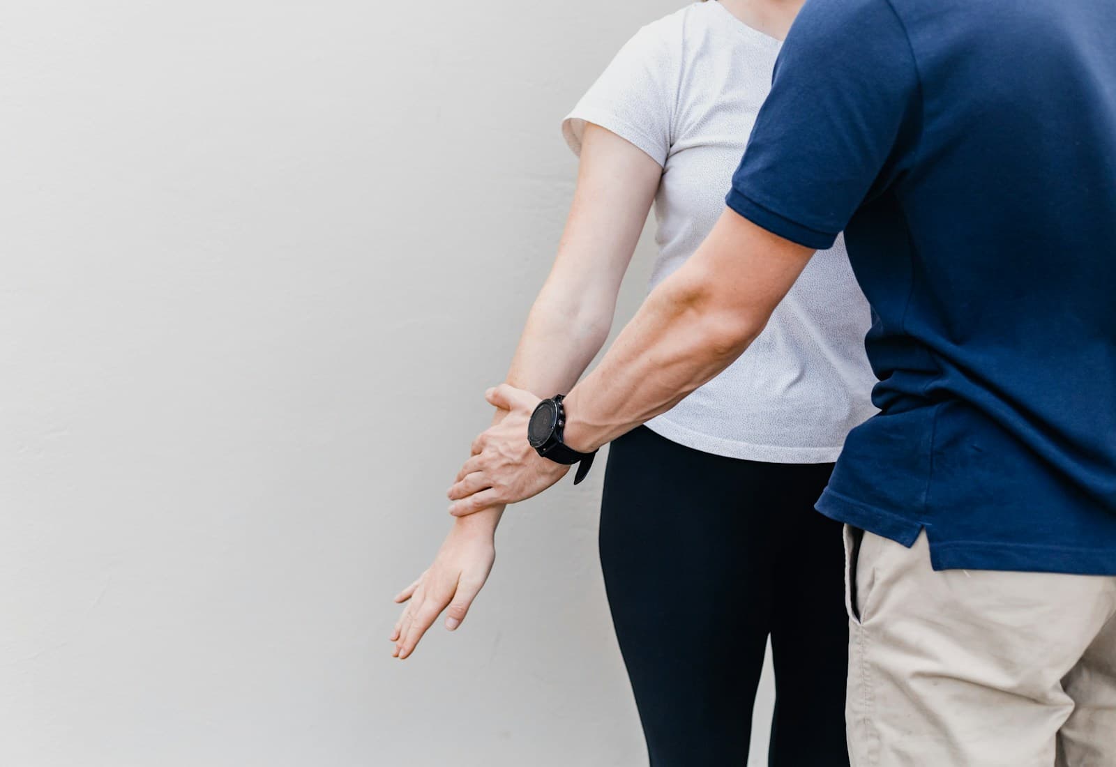 Chiropractor assessing a patient's shoulder and arm mobility during a consultation